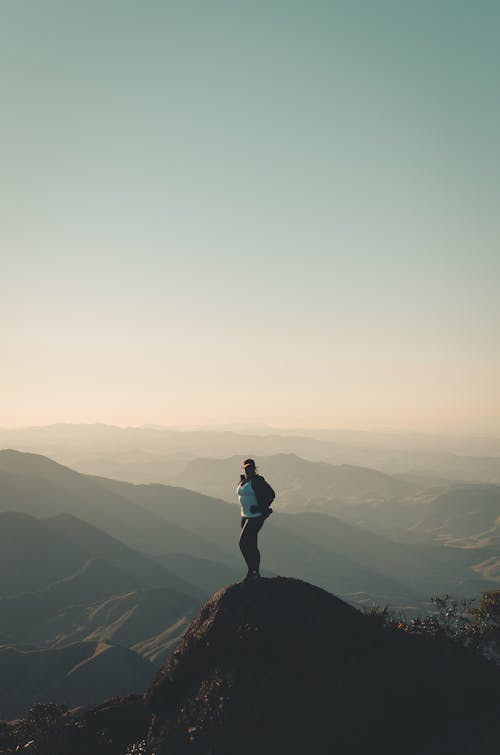 Person Standing on Mountain Peak 