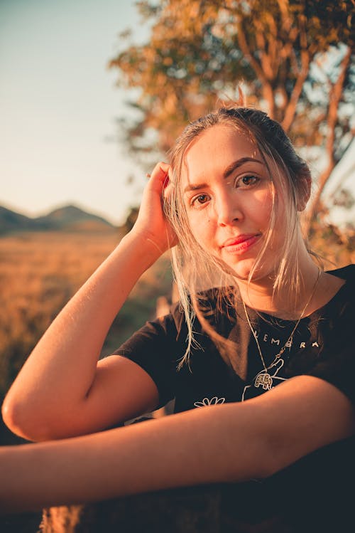 Woman in Black T-shirt Sitting Smiling at Camera