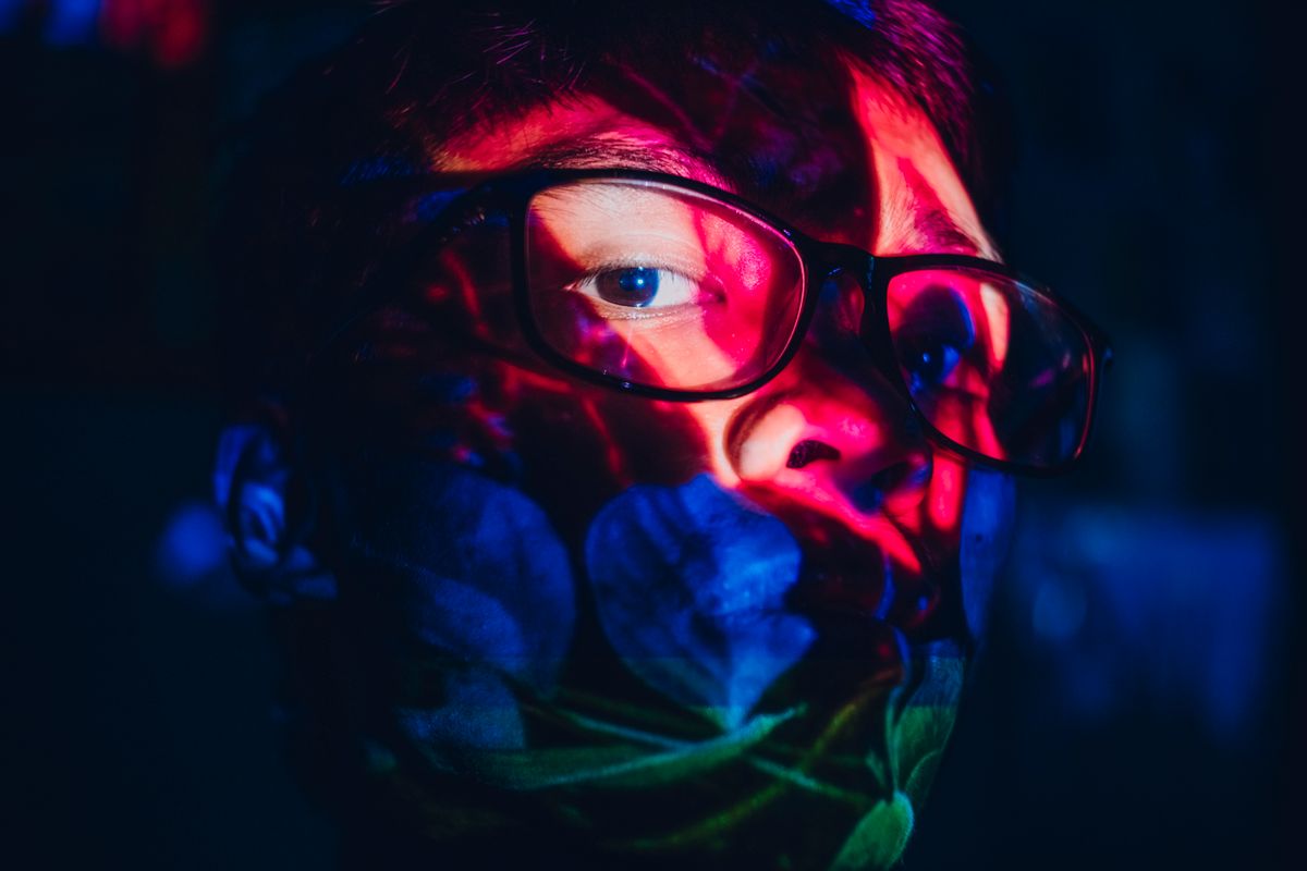 a person staring intensely at a glowing smartwatch screen