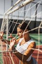 Beautiful Woman holding the Net of a Goal Post