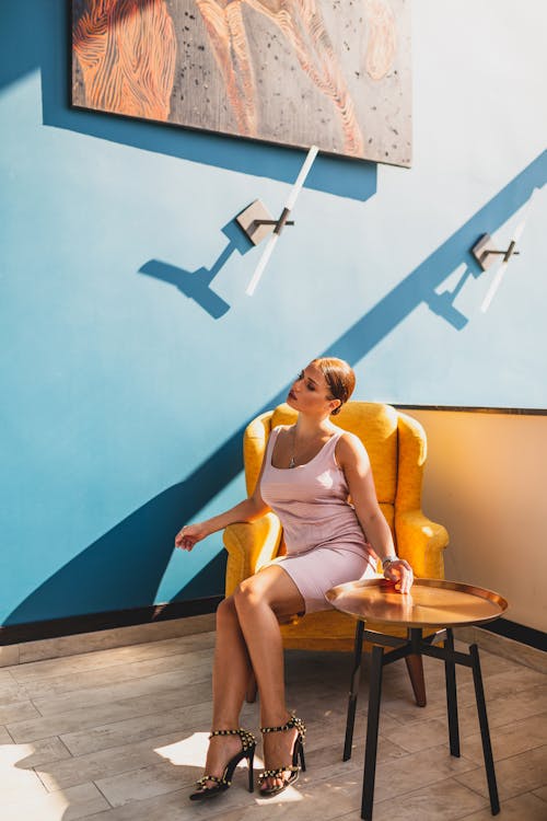 Free A Woman Sitting on Yellow Armchair Stock Photo