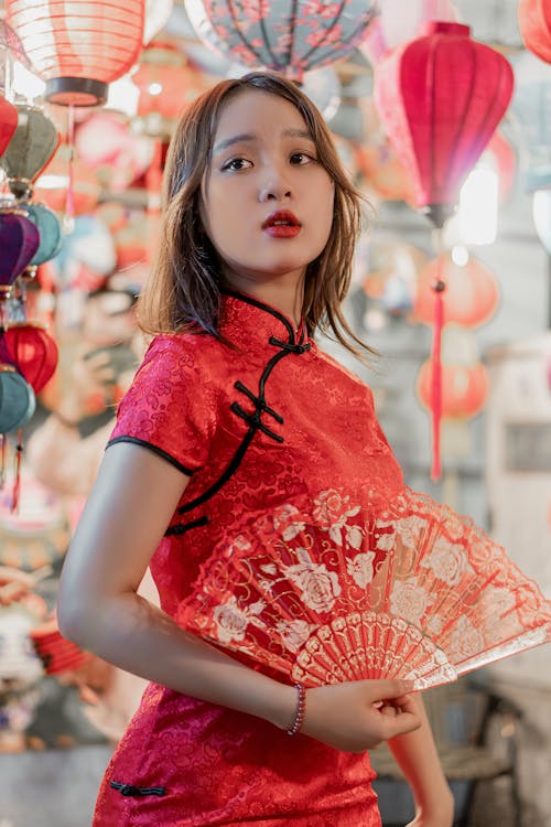 Woman in Red Dress Holding a Red Hand Fan