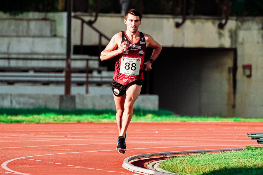 Determined sprinter driving forward on the stadium track