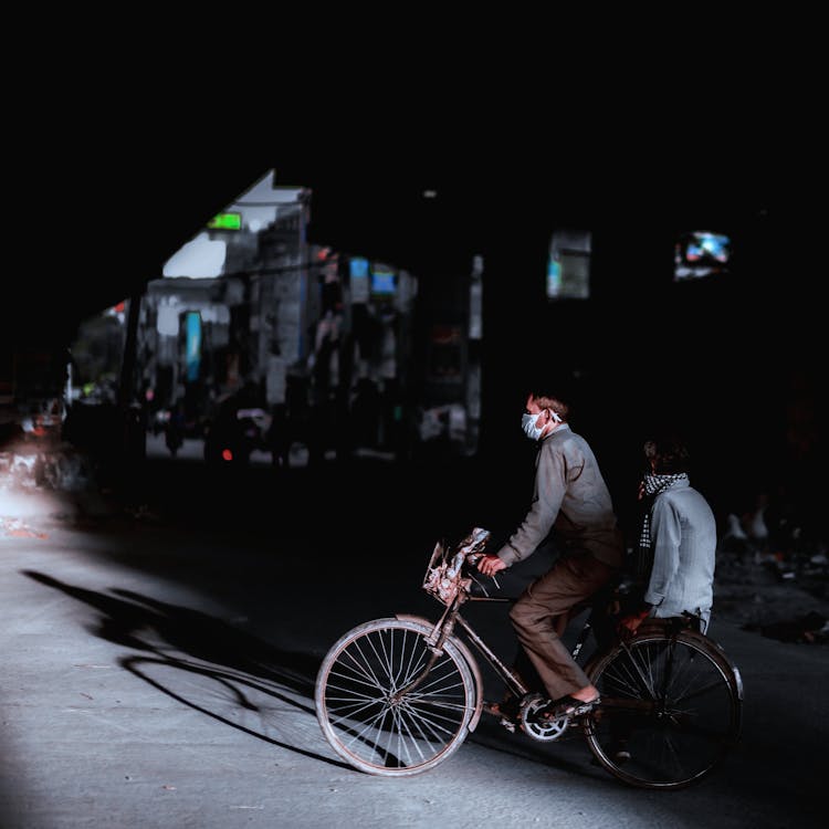 Anonymous People In Masks On Bicycle