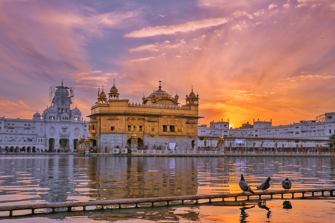 Golden temple near water in evening · Free Stock Photo