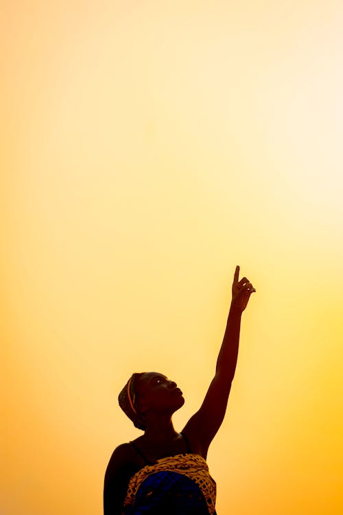 Free Black woman raising hand against skyline Stock Photo