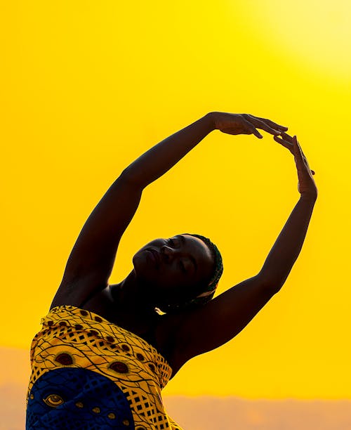 African woman dancing at sundown