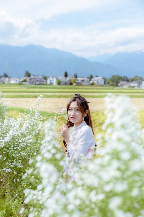Girl Standing in a Field amidst Flowers