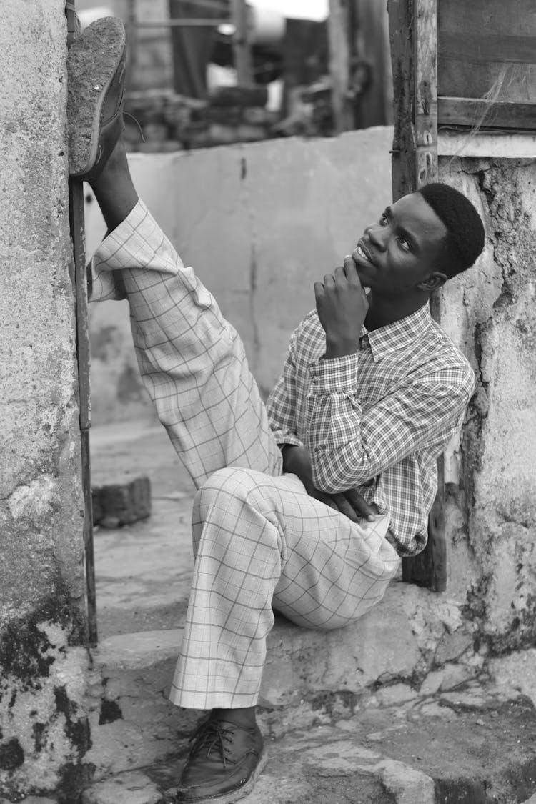 Man Sitting At Doorstep Neglected Building