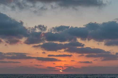 Free Picturesque scenery of endless rippling ocean with horizon under cloudy sky at sundown Stock Photo
