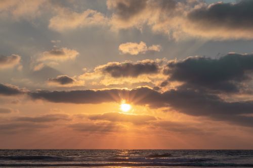Free Picturesque scenery of waving sea under colorful cloudy sky with shiny sun rays at dawn Stock Photo