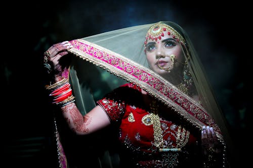 Dreamy Indian woman in traditional clothes with makeup and jewelries