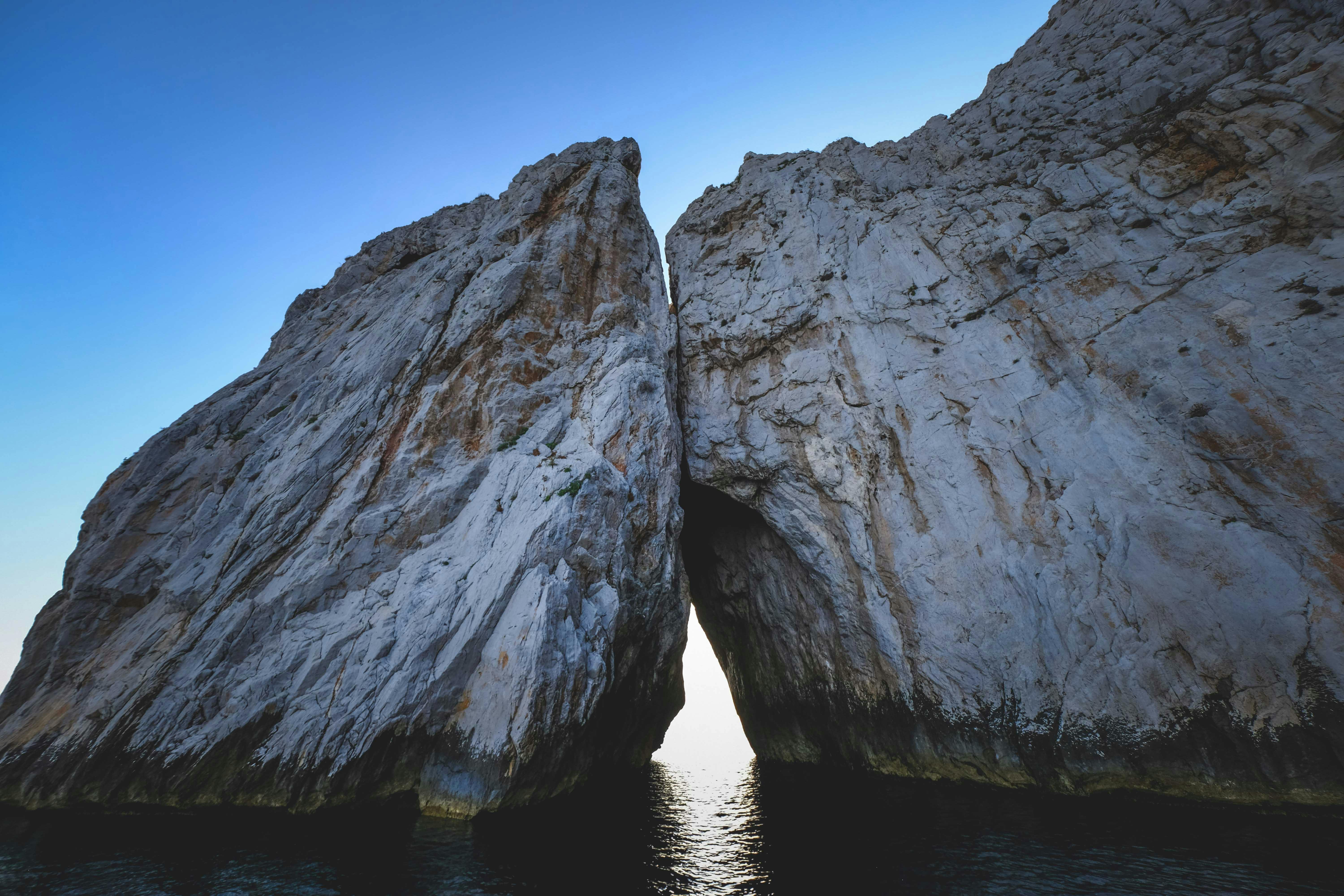 majestic rocky formation in sea under clear sky