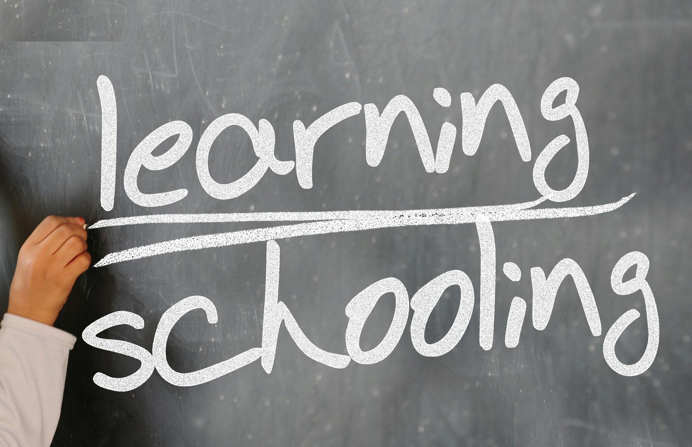 Chalkboard with "Learning Schooling" written