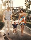 Parents Walking With Their Son and Holding His Hands 