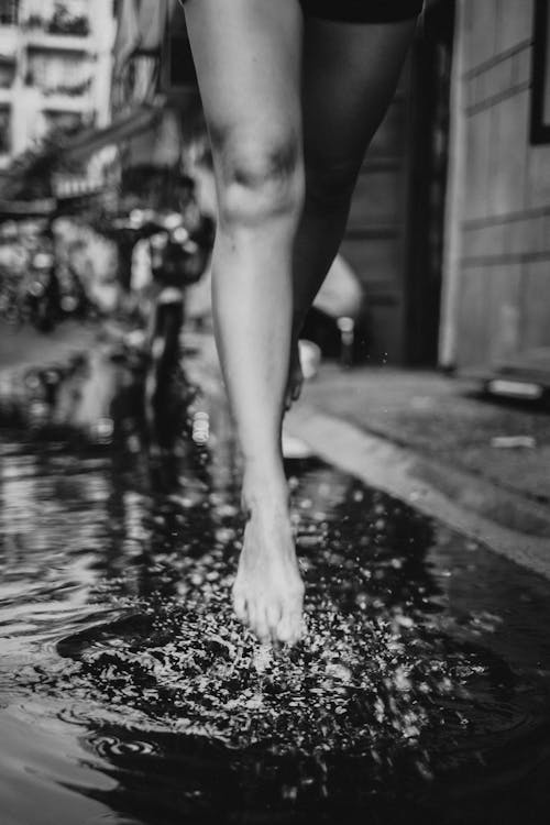 Woman running fast in splashing water on street