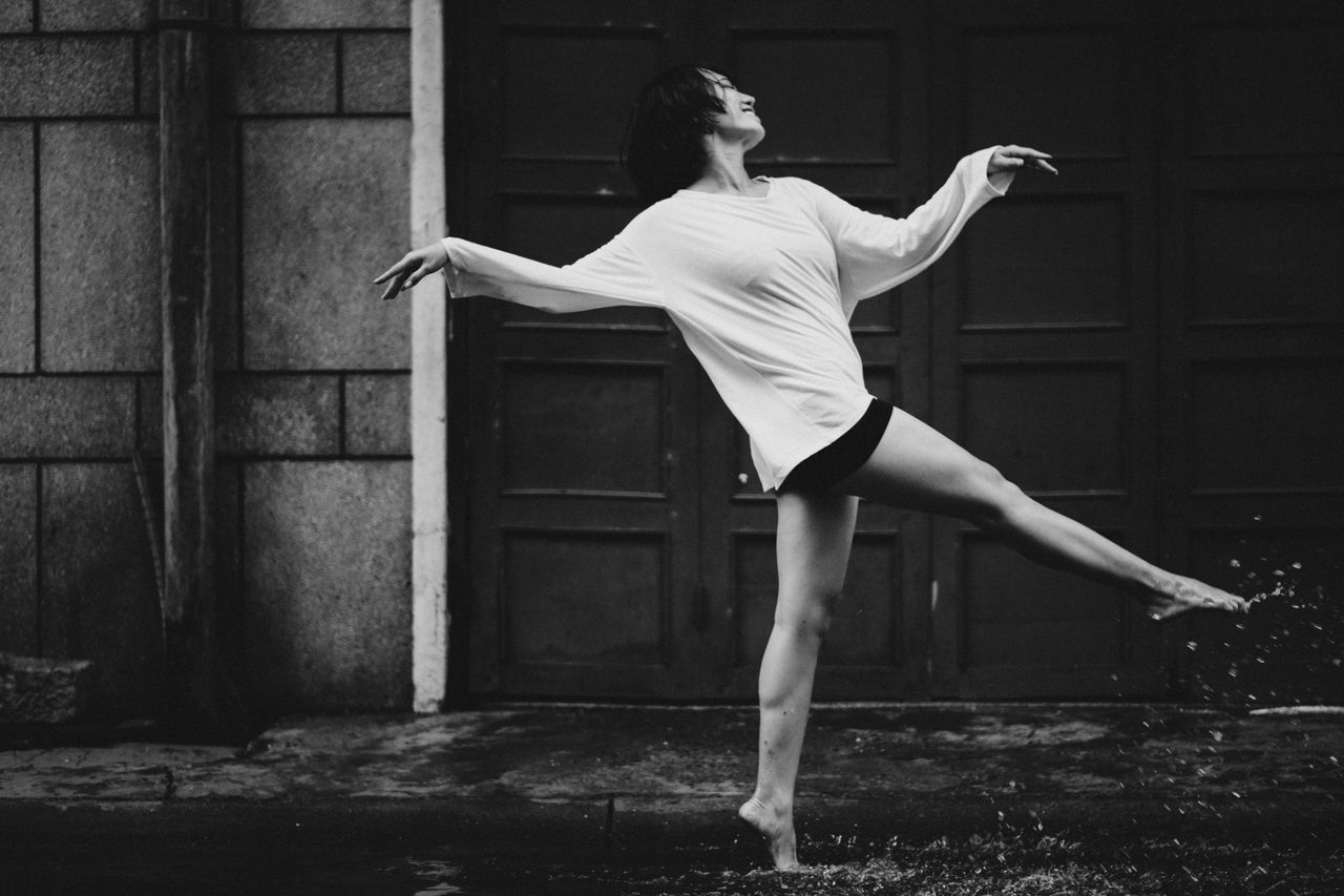 black and white full body side view of barefoot female dancer walking