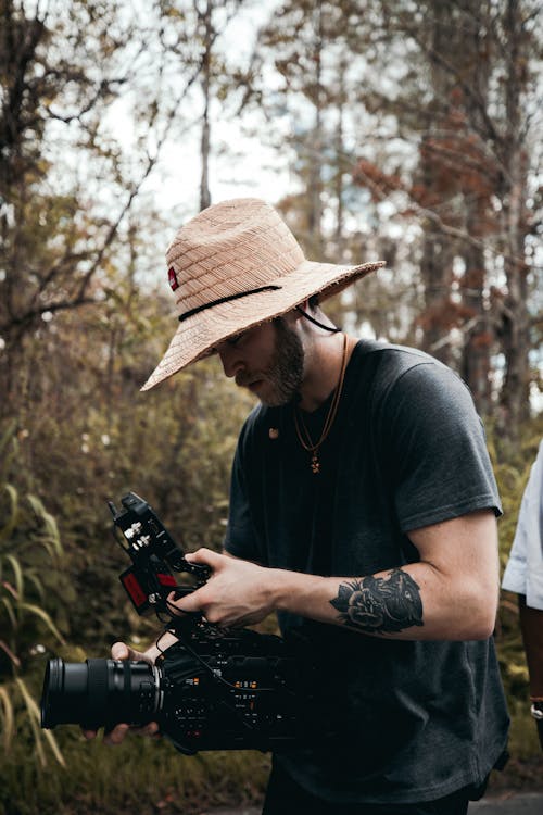 Videographer using a Black Video Camera 