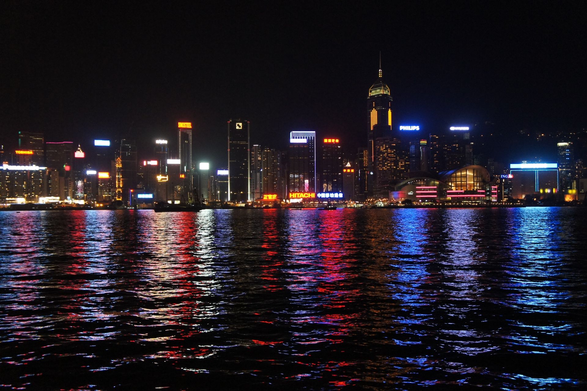 Stunning nighttime view of Hong Kong skyline reflecting on the water, showcasing vibrant city lights.