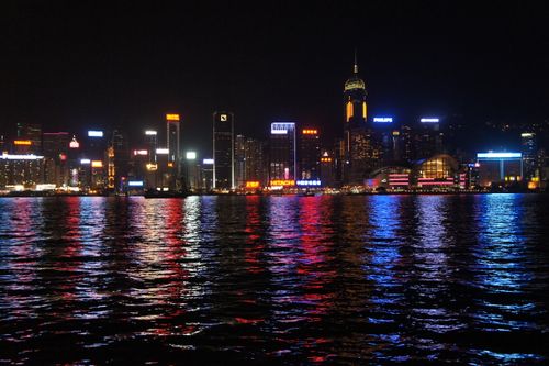 Free Stunning nighttime view of Hong Kong skyline reflecting on the water, showcasing vibrant city lights. Stock Photo