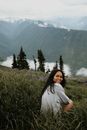 Young ethnic woman sitting on hill slope