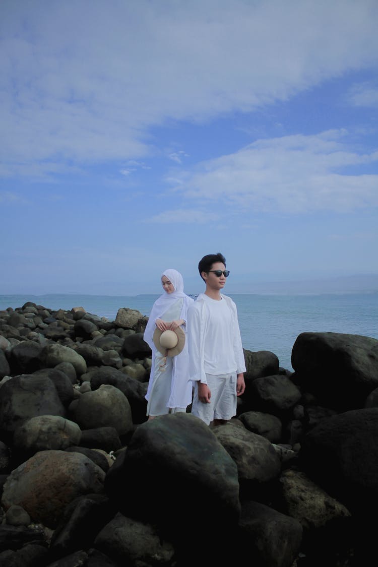 Couple On Black Rocks On Beach