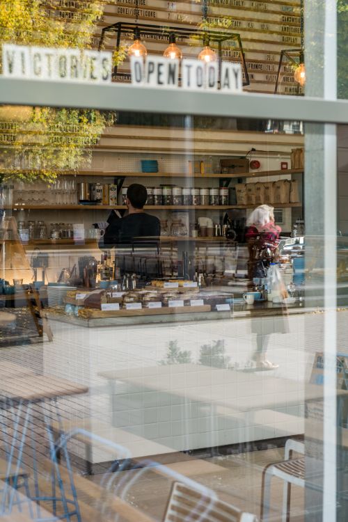 Free Cozy café interior seen through glass window, capturing reflections and ambiance. Stock Photo