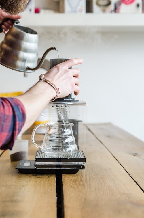 A Person Pouring Hot Water in the Cup