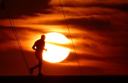 Free stock photo of man running in sunset