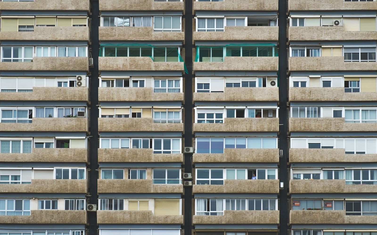 Symmetrical residential apartment building facade with balconies and windows