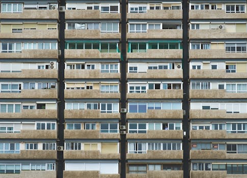 Symmetrical view of a residential building facade with balconies and windows in Valencia, Spain.