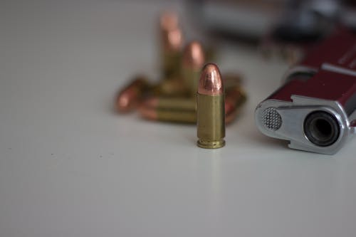 Free Close-up of Bullet Beside a Gun  Stock Photo