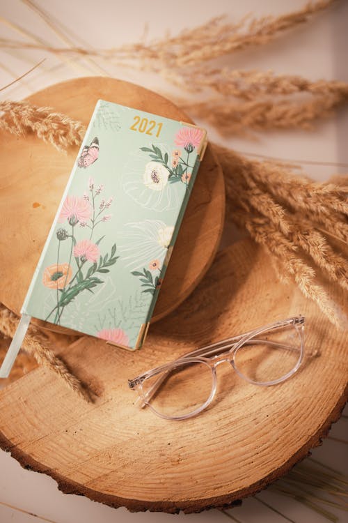 Ladies 2021 year diary and eyeglasses on wooden boards