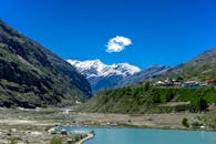 在白雪皑皑的山峰和清澈的蓝天下，吉斯帕山谷的迷人景色中，宁静的湖泊格外动人