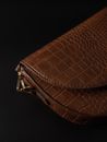 Brown leather purse on black background