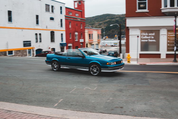 Blue Cabriolet On Asphalt Road