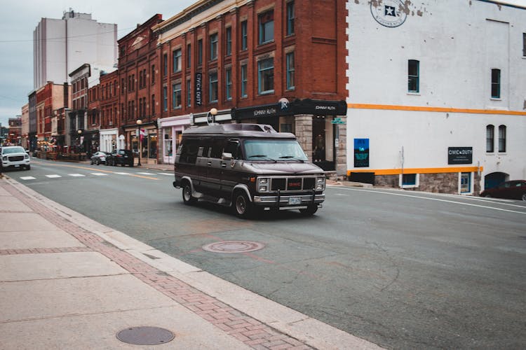 Black Minivan Driving On Asphalt Road