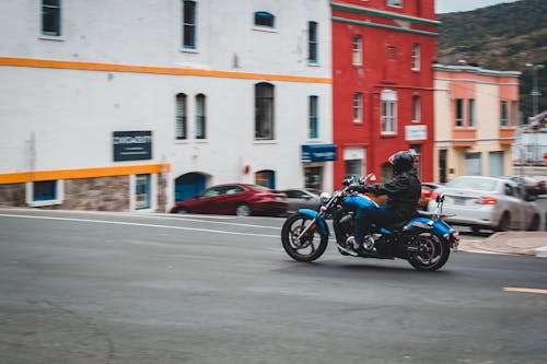Free Anonymous man driving motorcycle on road Stock Photo