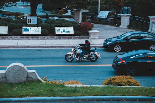 Unrecognizable man riding motorbike on road