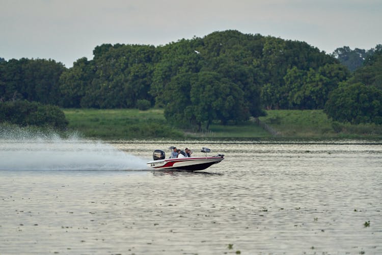 People Riding A White And Red Speed Boat On A River