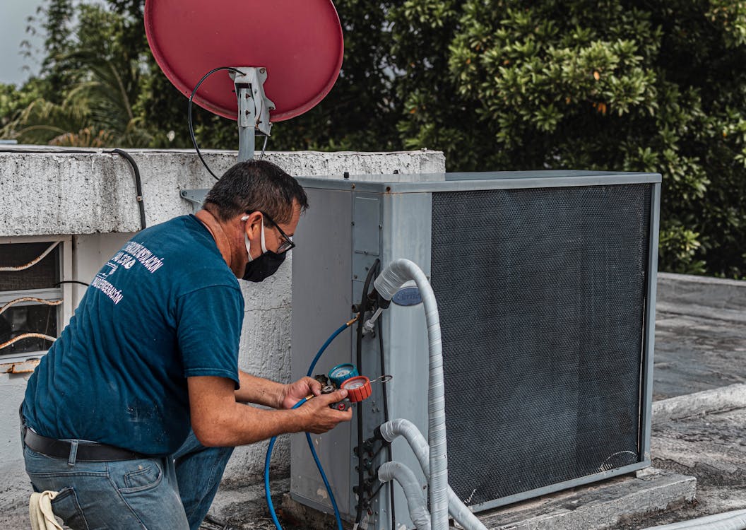 Free Man Checking an Air Conditioner repair Stock Photo