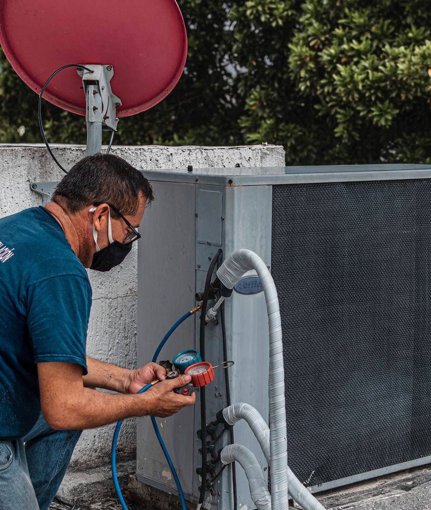 HVAC technician checking refrigerant pressures with manifold gauges