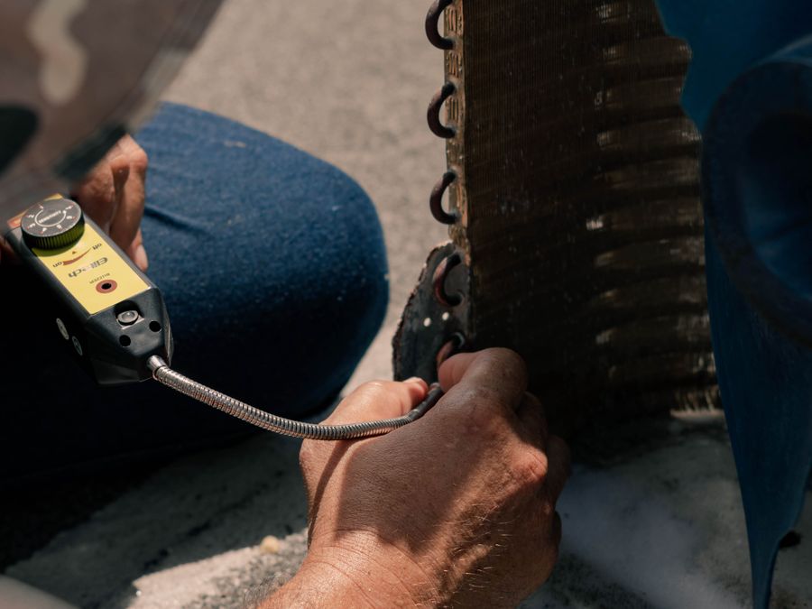 Technician performing air conditioning maintenance