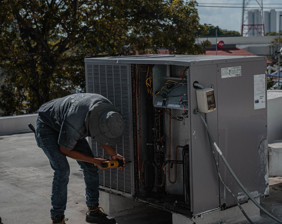 Technician servicing a rooftop air conditioning unit