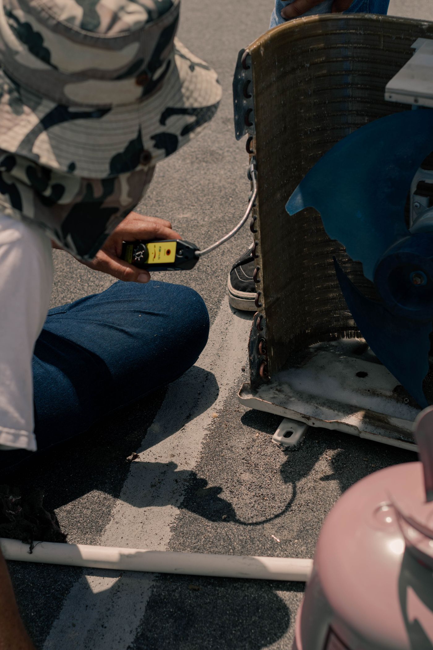 Technician testing an air conditioning unit with a multimeter