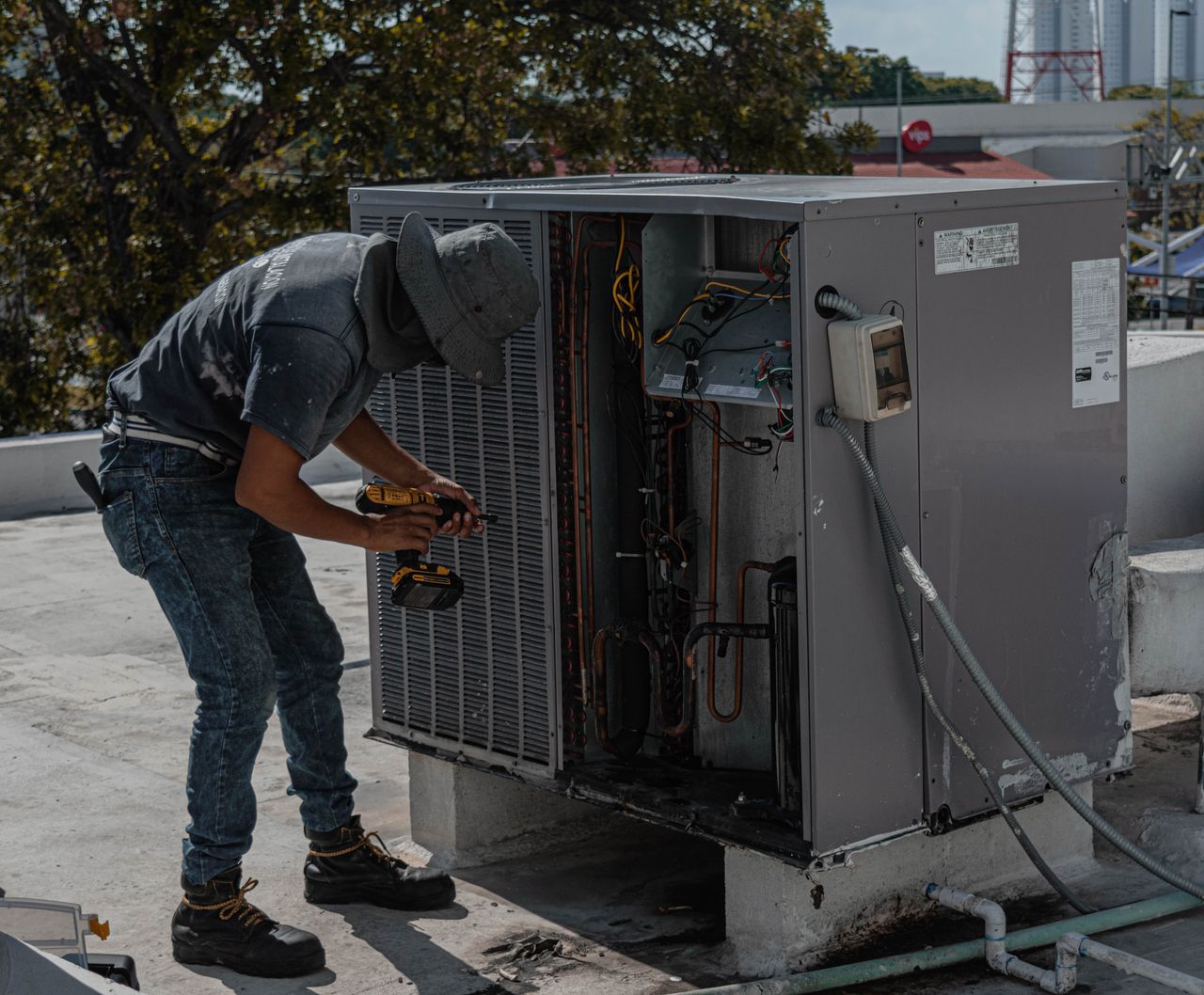 Technician drilling an air conditioner casing during installation