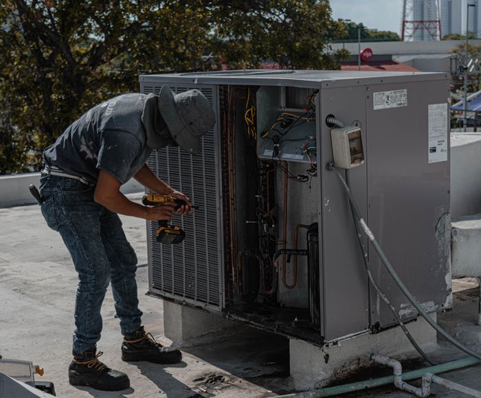 Técnico reparando unidade externa de ar condicionado