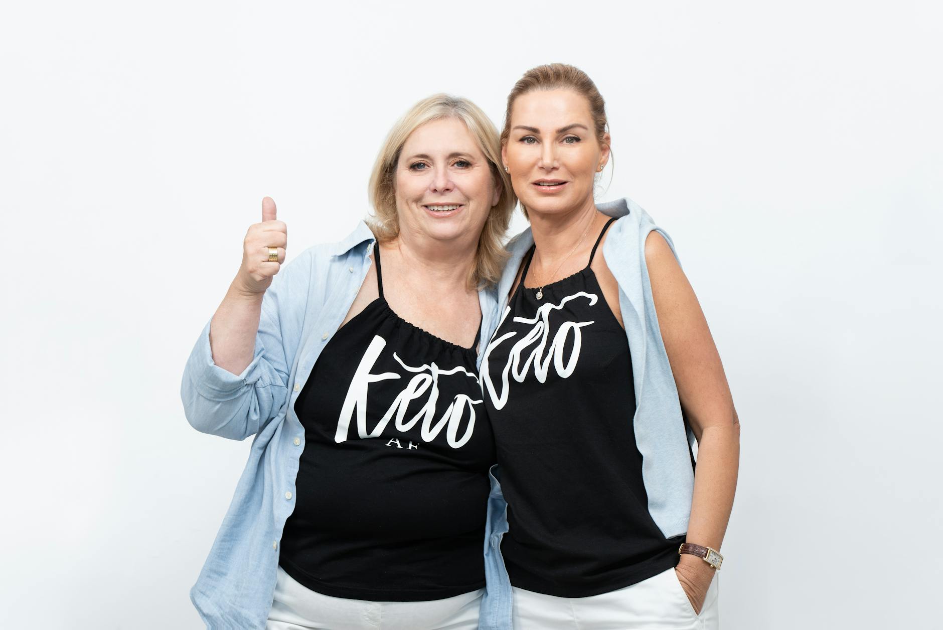 Two women wearing matching keto-themed shirts, expressing happiness and togetherness.