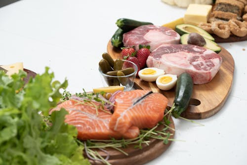 Free Assorted Fresh Meat and Salmon with Fruits and Vegetables on a Chopping Board Stock Photo