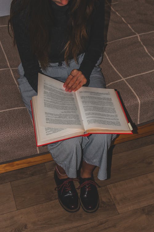 A Person Sitting on a Bench Holding a Book